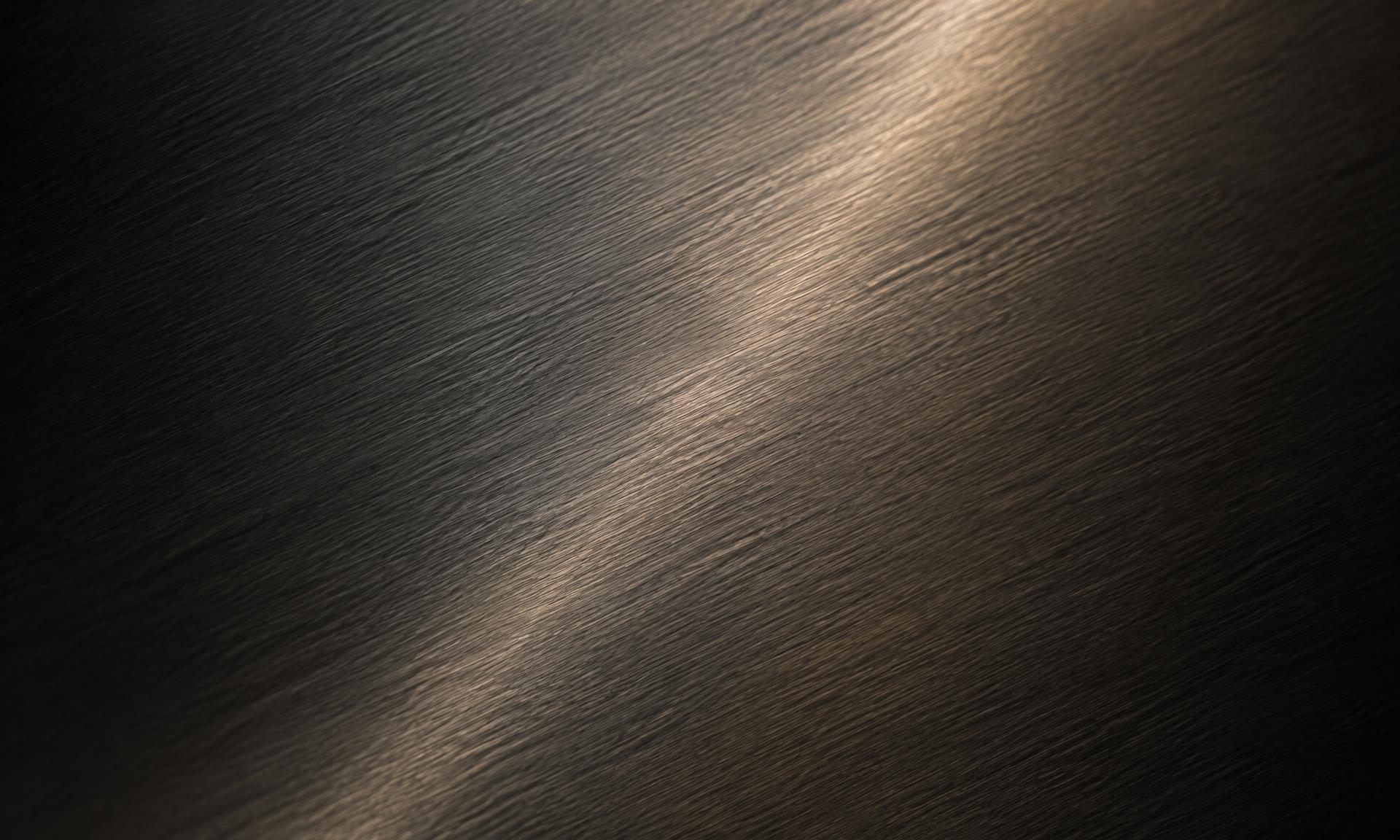 Dark brushed steel surface with a warm sheen